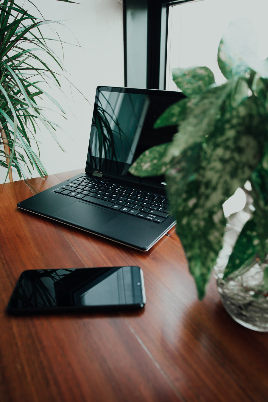 Laptop and phone used to test Shopify cart sync across devices